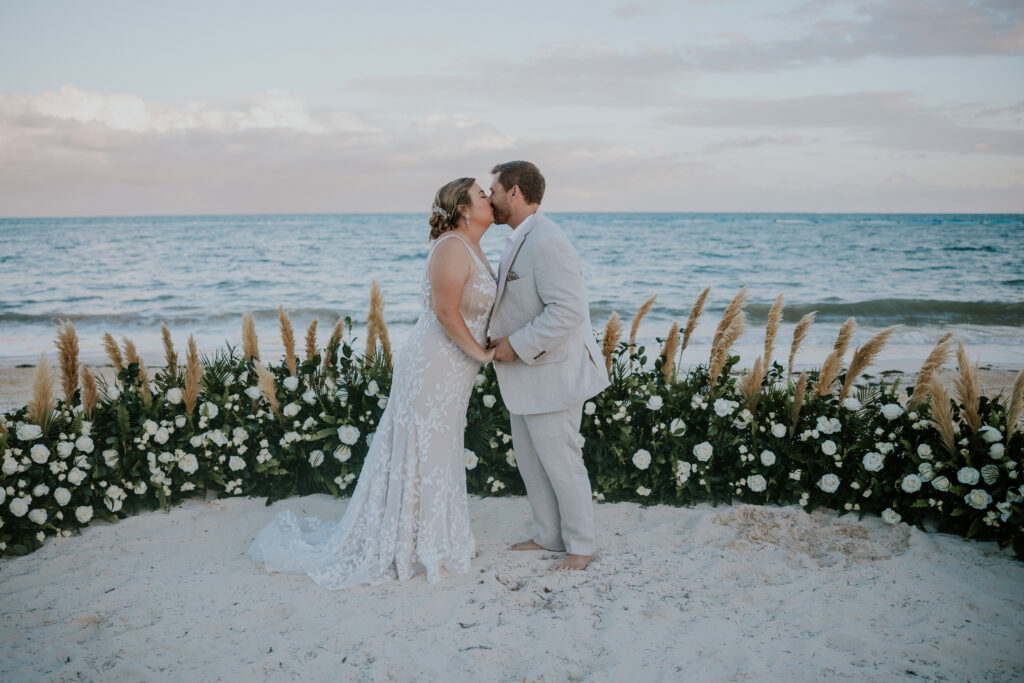 Destination wedding photographer captures bride and groom kissing on beach after destination Cancun Mexico wedding