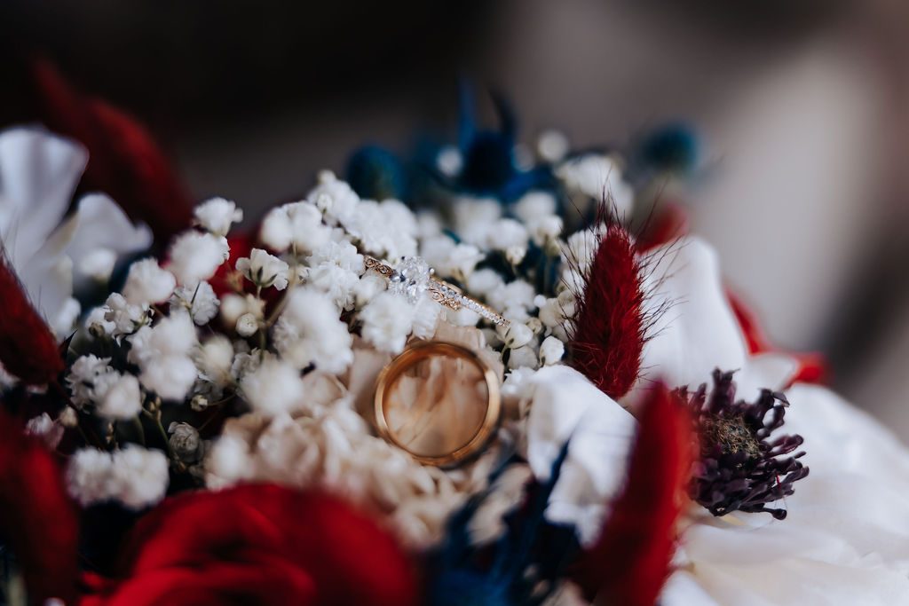 Destination wedding photographer captures bridal bouquet with wedding rings sitting on top