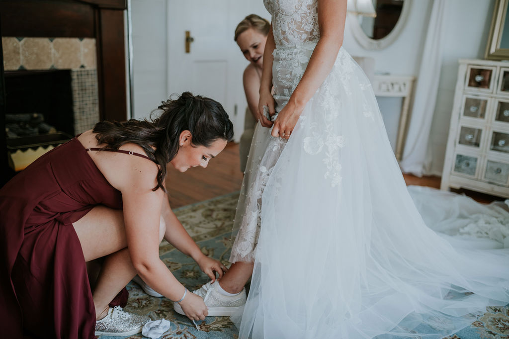 Destination wedding photographer captures bride getting shoes put on