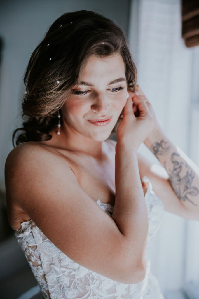 Destination wedding photographer captures bride putting on earrings