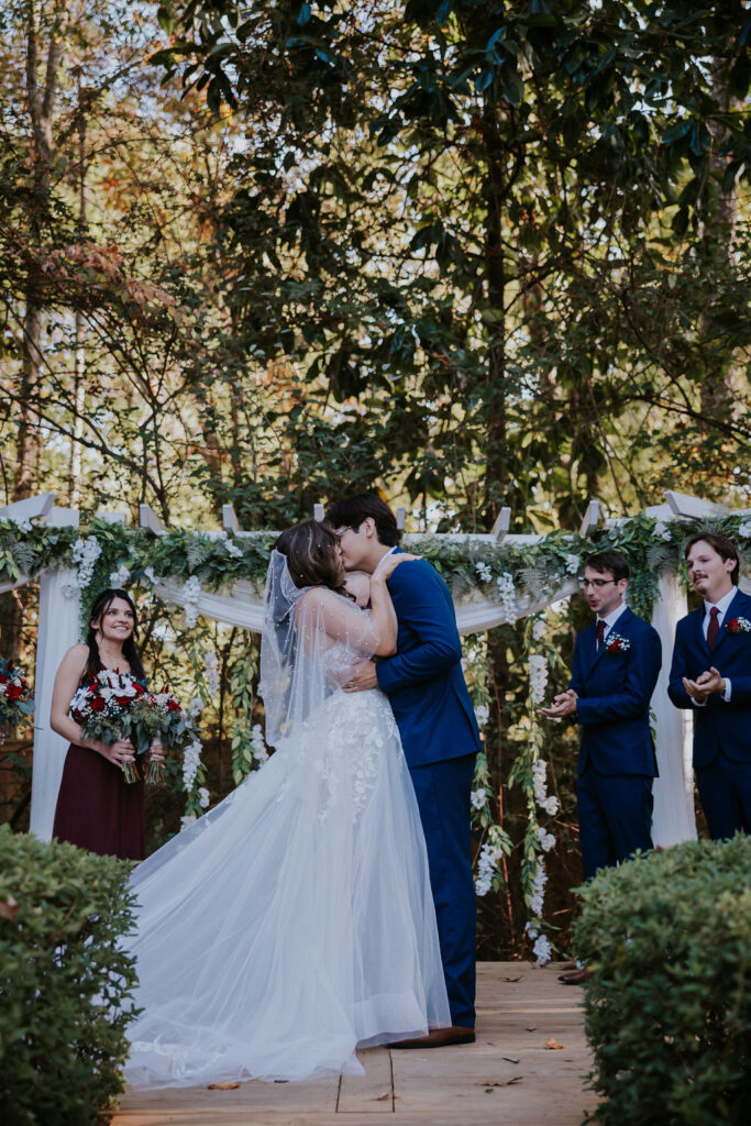 Destination wedding photographer captures bride and groom kiss after wedding ceremony celebrating recent marriage