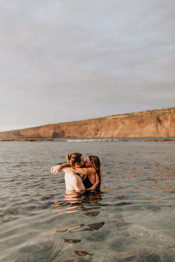 Destination Wedding Photographer captures couple kissing in water during visit to the Big Island