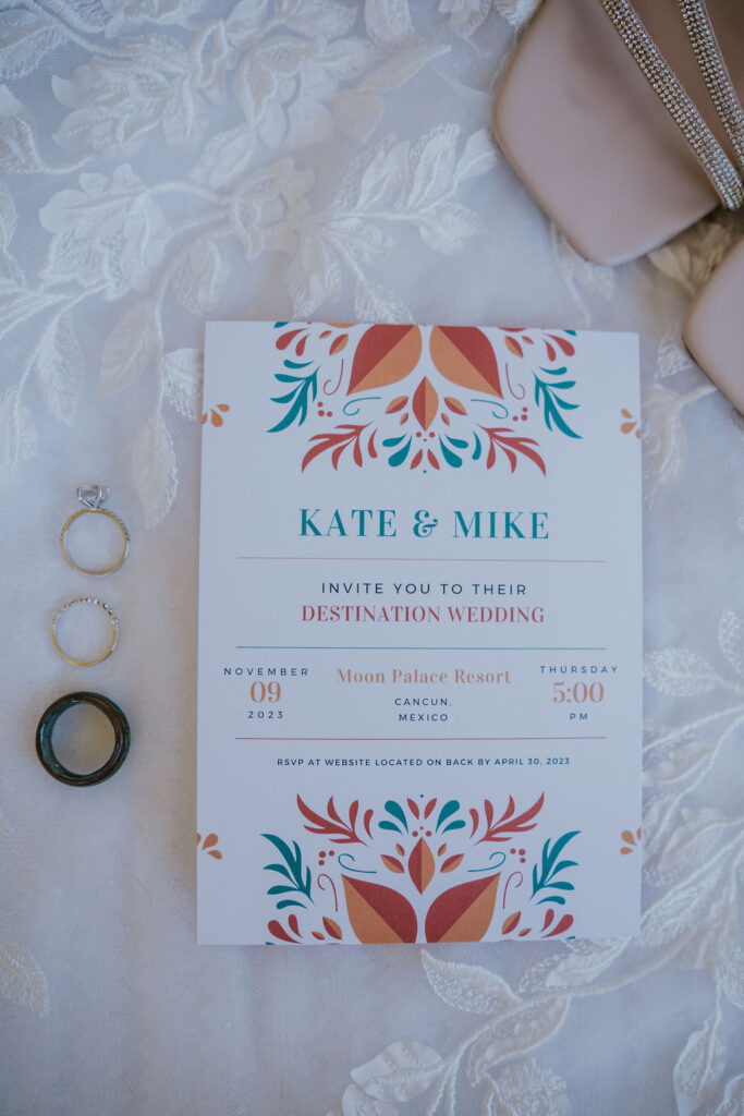 Destination wedding photographer captures tropical cancun wedding invitation with wedding rings alongside