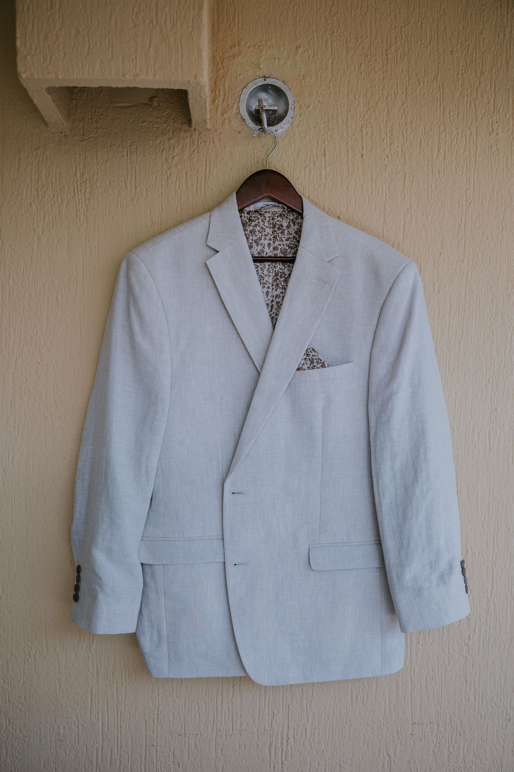 Destination wedding photographer captures groom's suit hanging on hanger