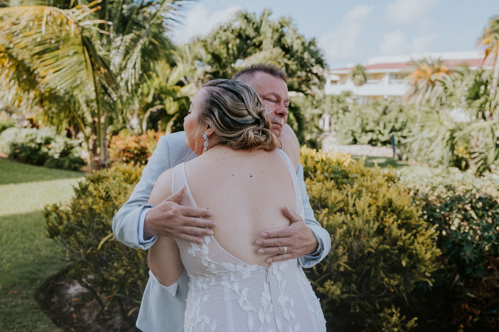 Destination wedding photographer captures bride hugging father after first look