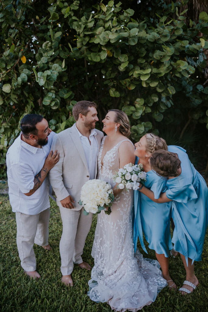 Destination wedding photographer captures couple looking at one another while wedding party celebrates