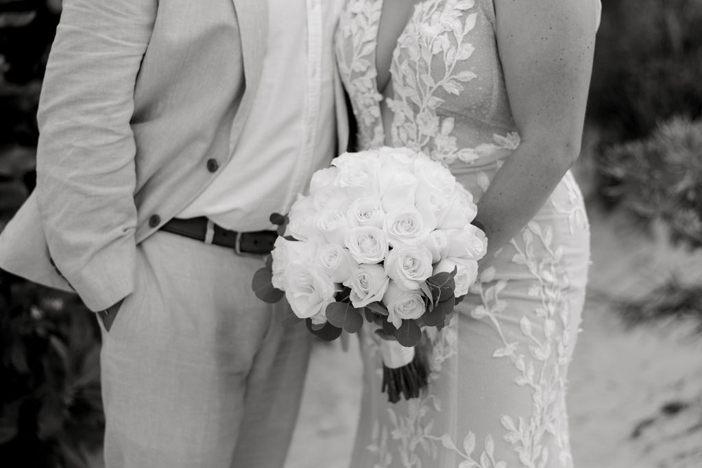 Destination Wedding Photographer captures bride and groom standing together holding bouquet