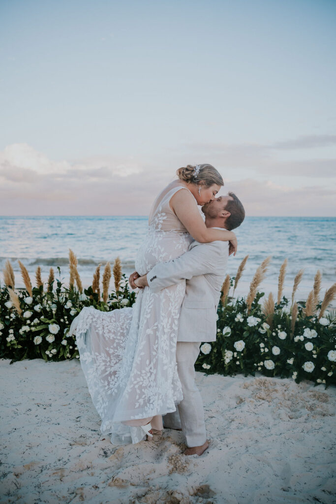 Destination Wedding Photographer captures groom lifting bride and kissing her