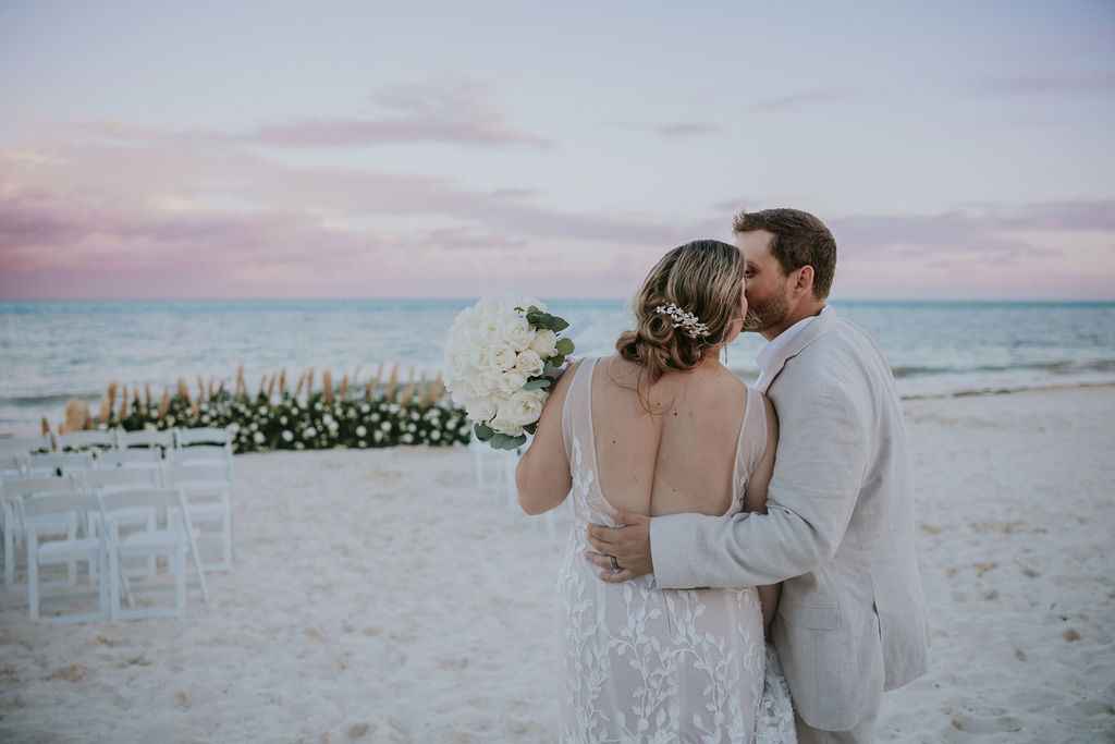 Destination wedding photographer captures bride and groom embracing at sunset