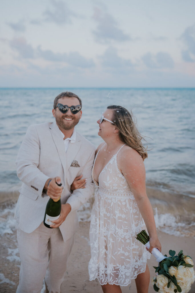 Destination wedding photographer captures bride and groom celebrating with champagne pop