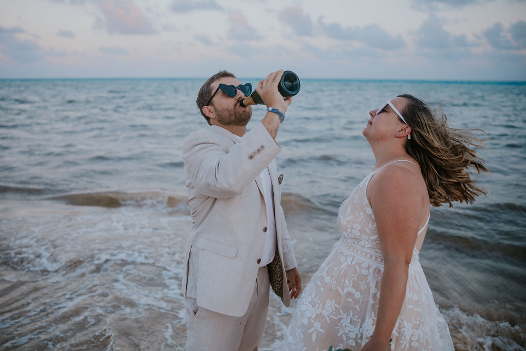 Destination wedding photographer captures groom drinking champagne from the bottle
