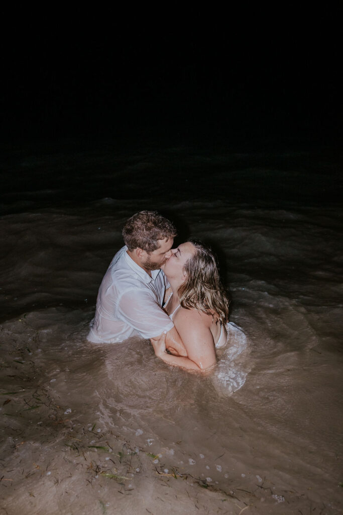 Destination Wedding Photographer captures bride and groom kissing in water