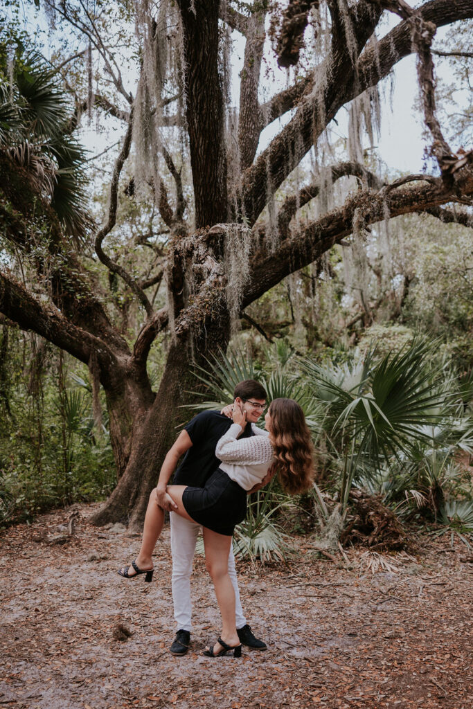 Destination wedding photographer captures dip kiss in front of tree
