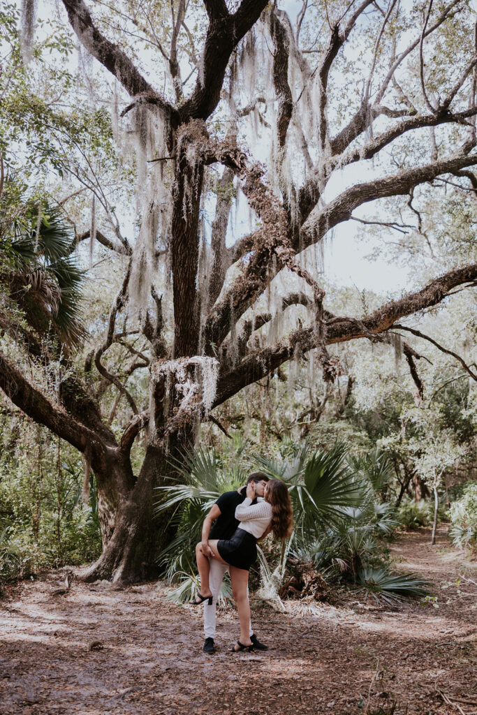 Destination wedding photographer captures couple kissing under tree