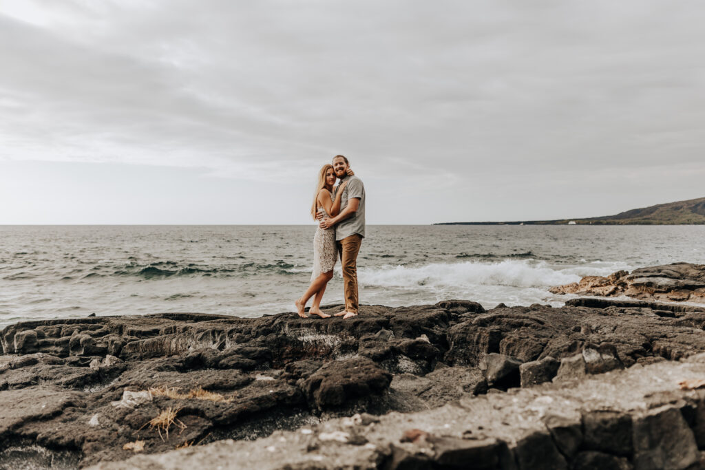 Destination Wedding Photographer captures newly engaged couple standing on beach in Big Island Hawaii