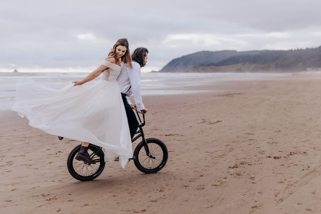 Destination Wedding Photographer captures groom riding bike with bride hanging on the back