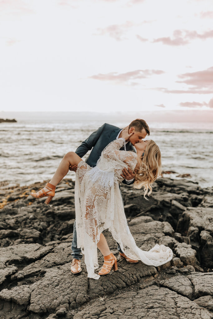 Destination Wedding Photographer captures dip kiss between bride and groom after tropical Hawaii beach wedding