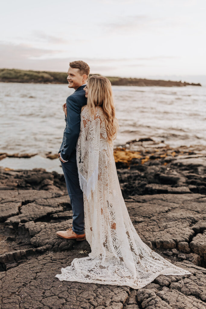 Destination Wedding Photographer captures bride hugging groom from behind