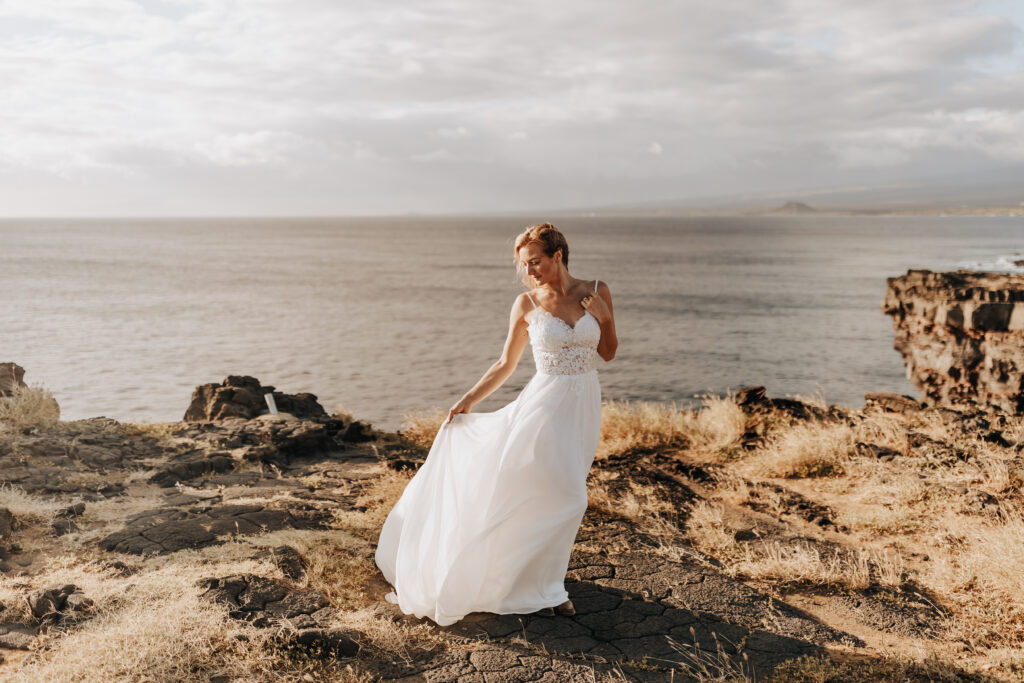 Destination Wedding Photographer captures bride swinging dress in the wind after tropical Hawaii beach wedding