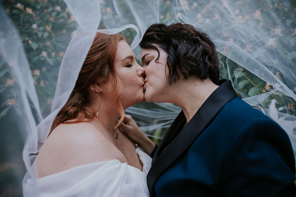 Destination Wedding Photographer captures brides kissing under veil at top downtown wedding venues in Nashville