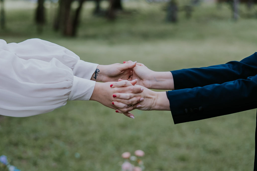 Destination Wedding Photographer captures brides holding hands during intimate ceremony in Maine