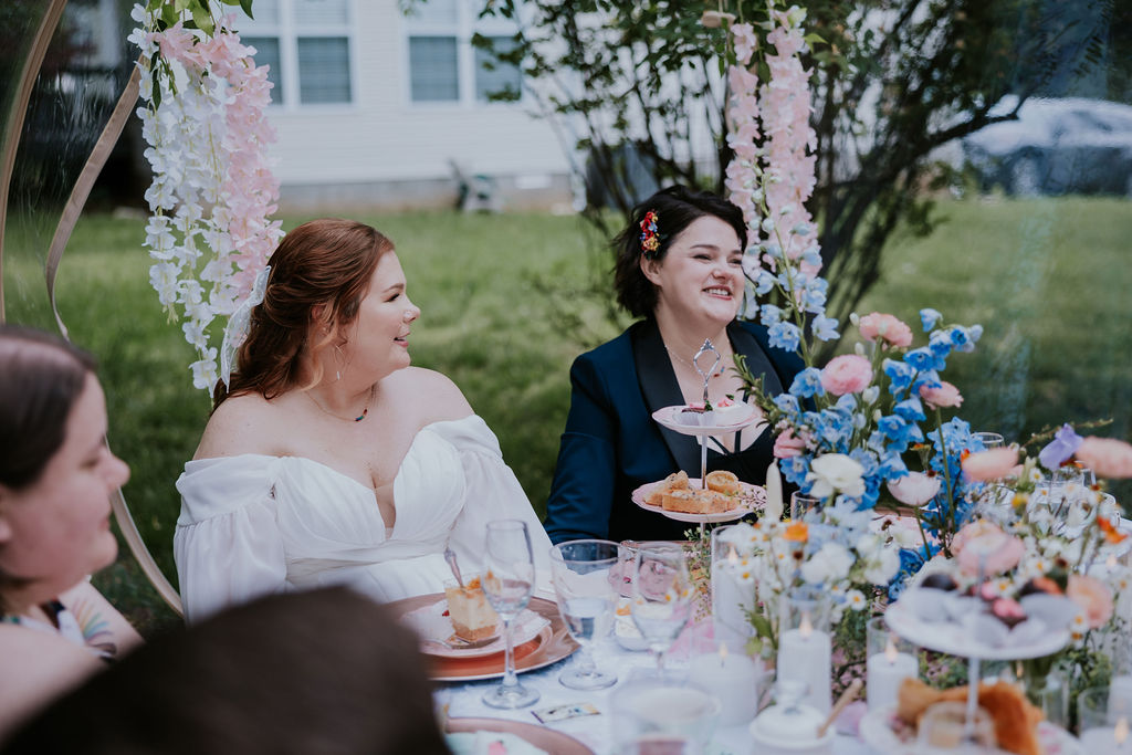 newly married couple sitting at table during cocktail hour celebrating with guests