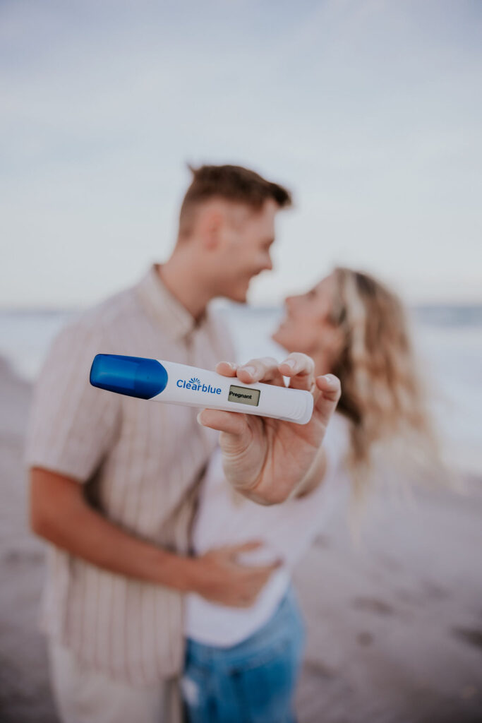 Destination Wedding Photographer captures man and woman hugging while holding pregnancy test