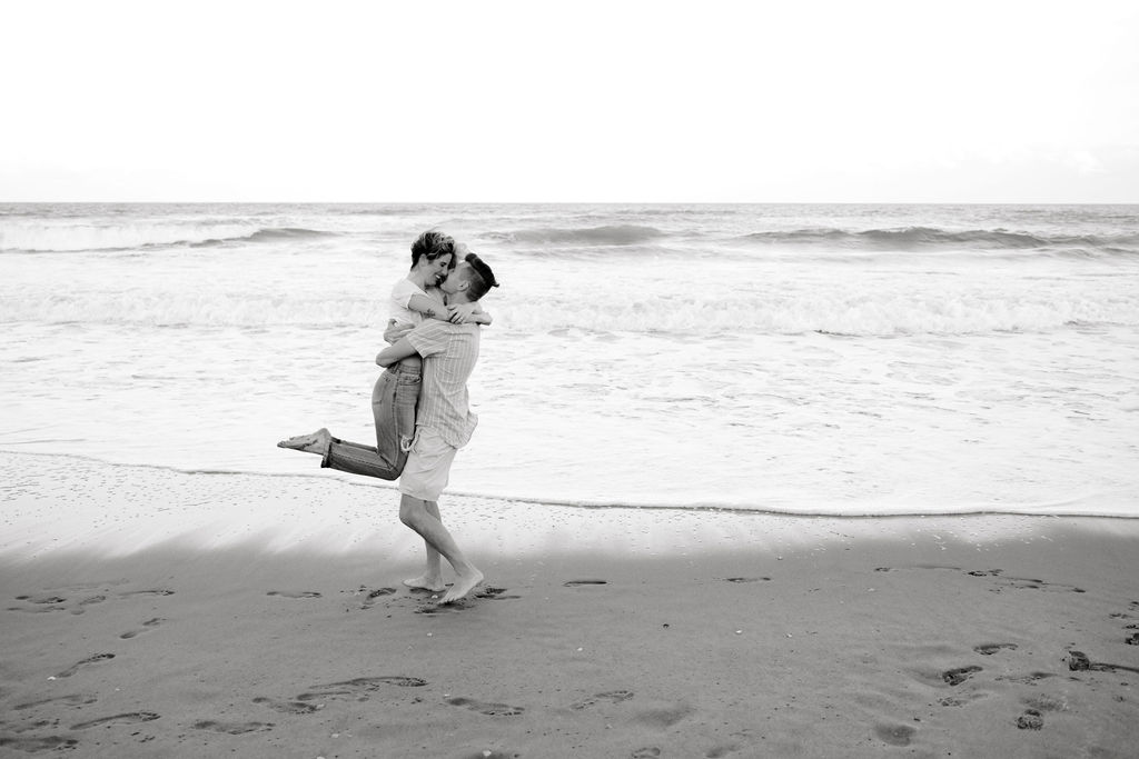 Destination Wedding Photographer captures man catching woman and lifting her up