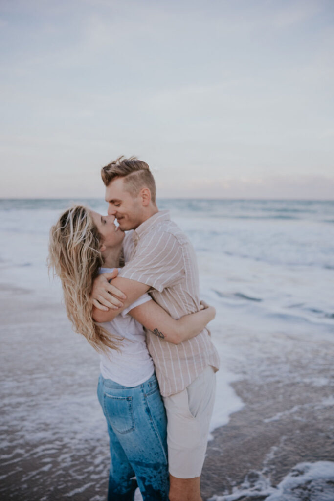 Destination Elopement Photographers capture man and woman kissing in the ocean