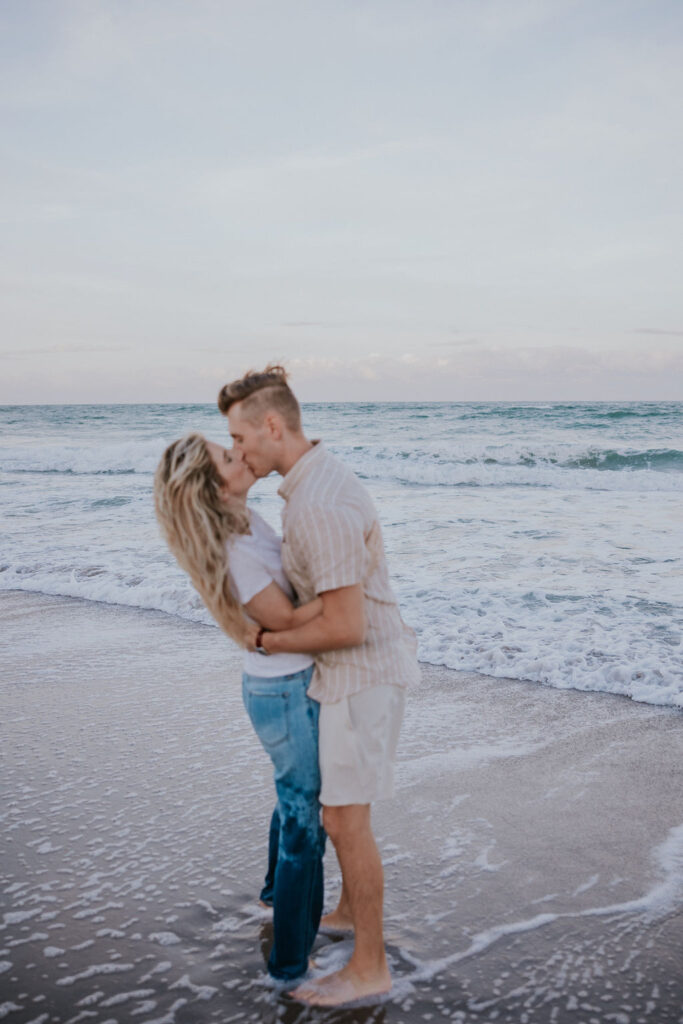 Destination Wedding Photographer captures couple kissing in ocean