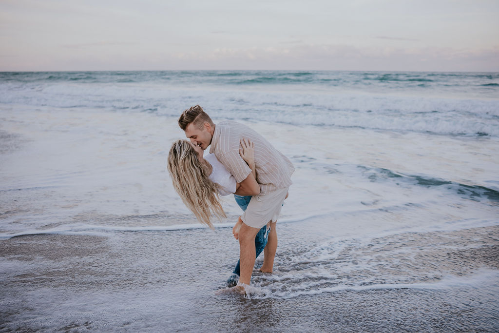 Destination Wedding Photographer captures man dip kissing woman in water