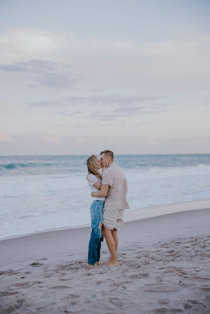 Destination Wedding Photographer captures couple kissing on beach after Indian Harbour beach maternity photos