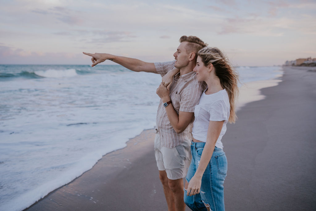 Destination Wedding Photographer captures man pointing at ocean 