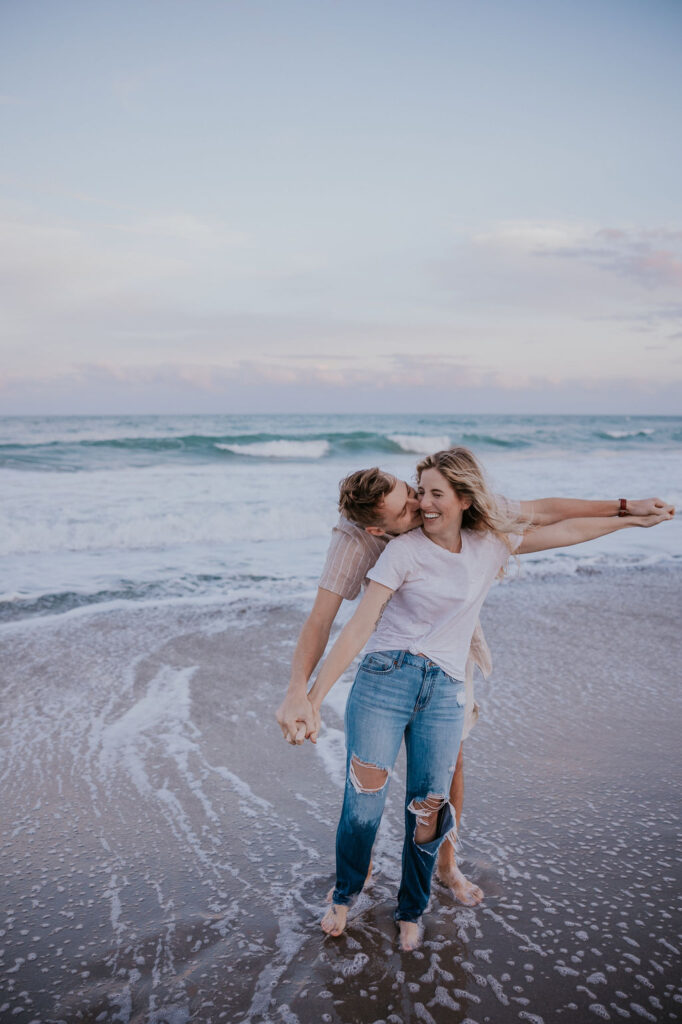 Destination Wedding Photographer captures man hugging woman in water