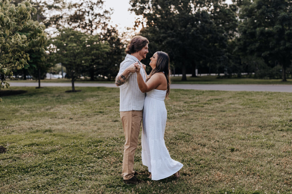 Nashville elopement photographer captures newly engaged couple dancing in field during summer date nights in Nashville