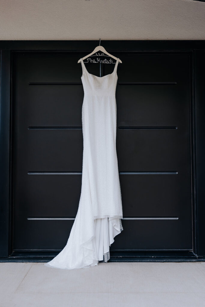 Destination Wedding Photographer captures wedding dress hanging from door