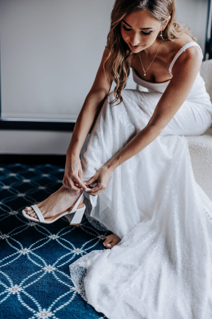 Destination wedding photographer captures bride putting on shoes before wedding