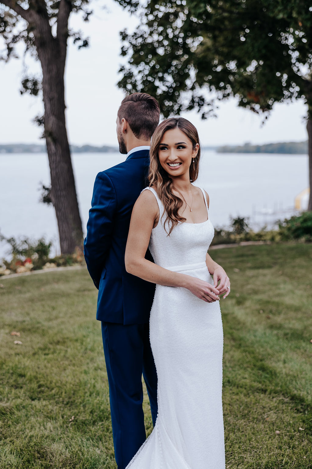 Bride beams during an emotional first look as she stands back-to-back with her groom, moments before their ceremony.