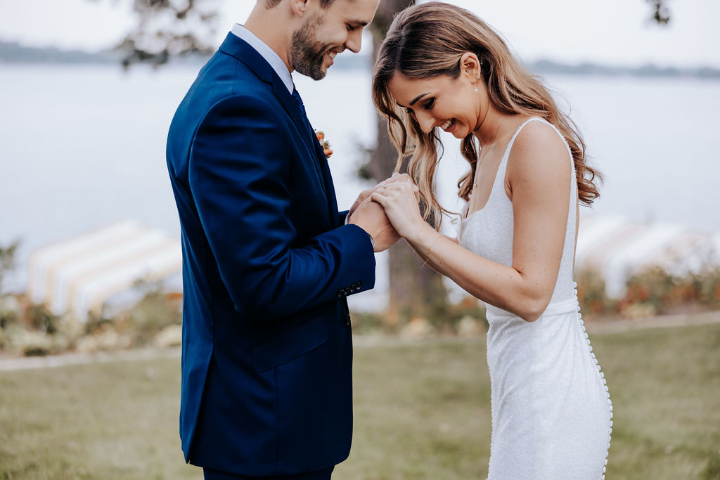 Destination wedding photographer captures bride holding groom's hands during first look