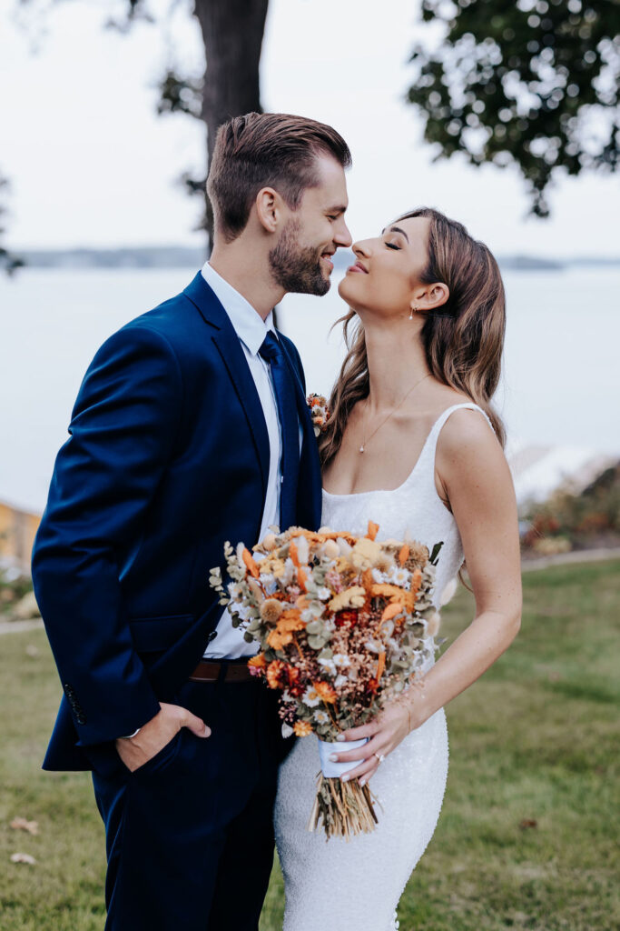 Destination wedding photographer captures couple hugging while bride holds bouquet