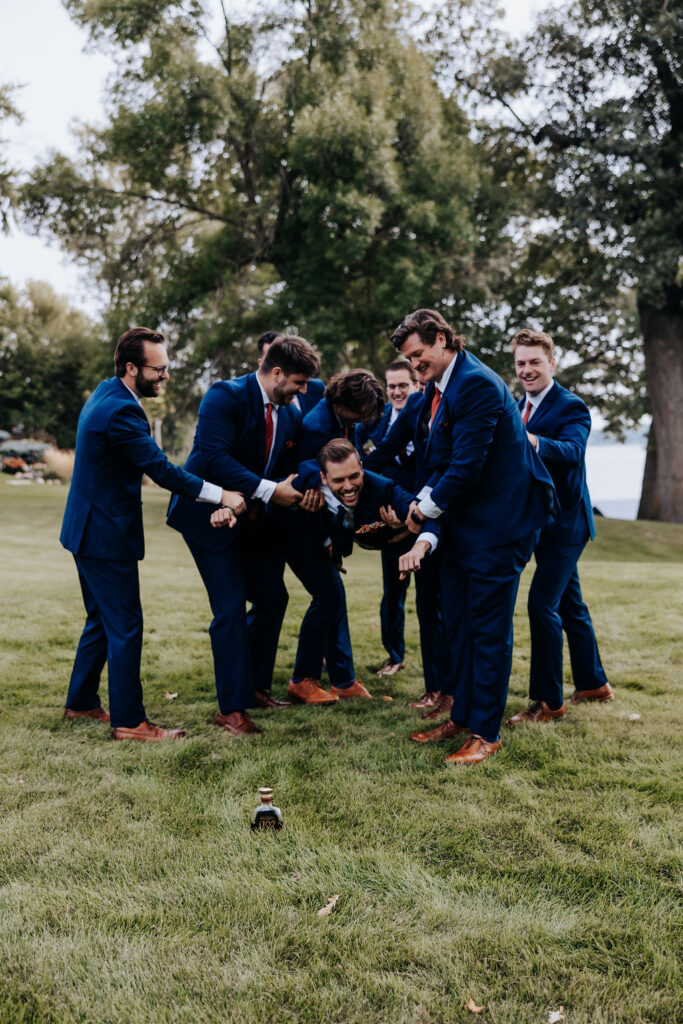 Destination wedding photographer captures groomsmen carrying groom