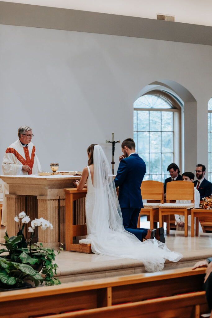 Destination wedding photographer captures couple at alter during Catholic wedding ceremony