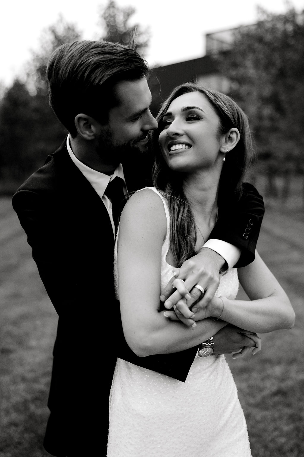 Destination wedding photographer captures groom hugging bride from behind