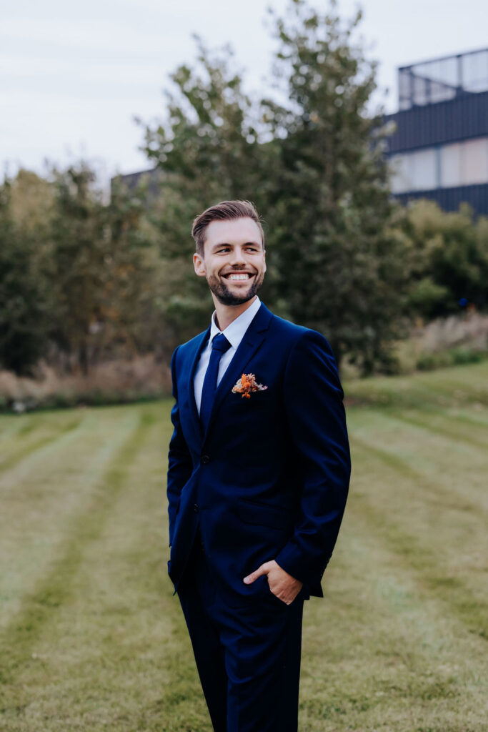 Destination wedding photographer captures groom with hands in pockets