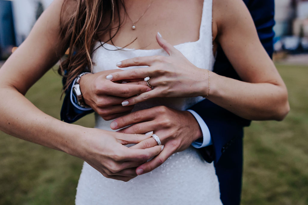 Destination Wedding Photographer captures bride and groom holding hands showing off their rings