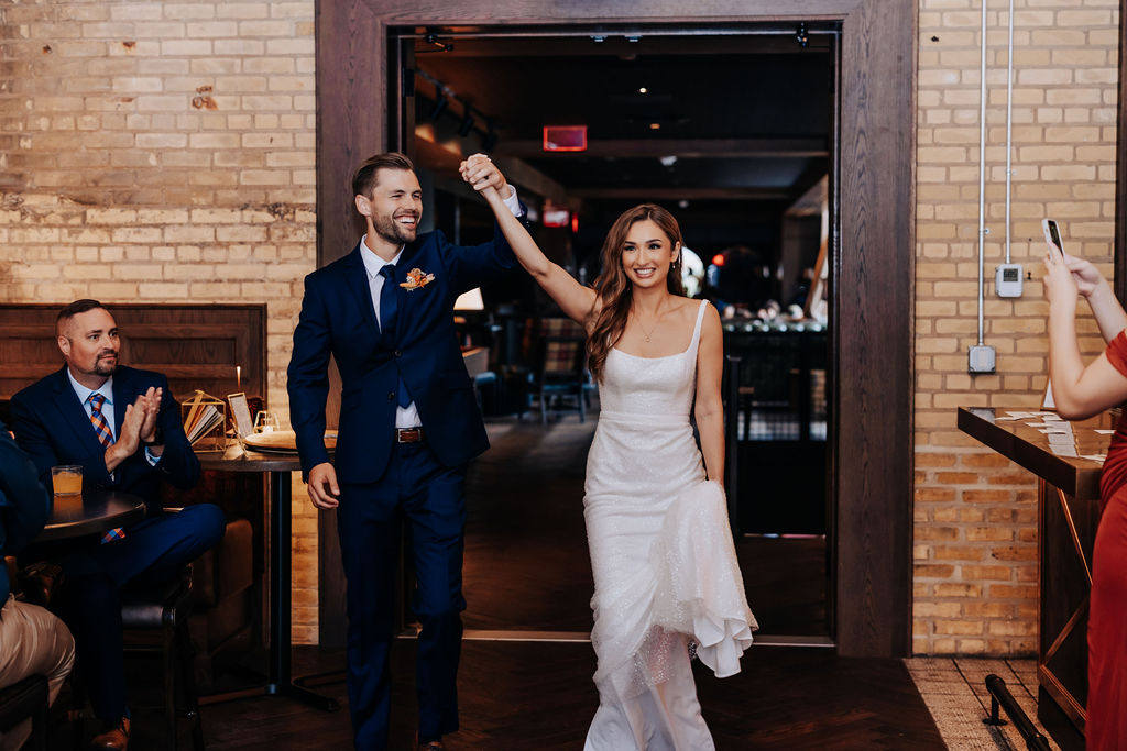 Destination wedding photographer captures bride and groom walking into reception