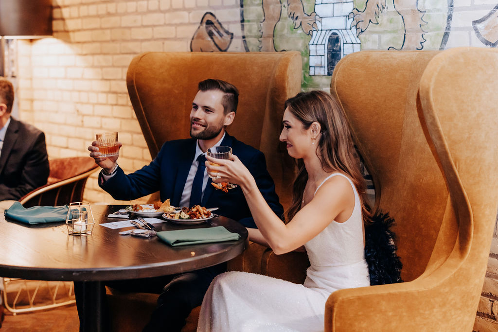 Destination wedding photographer captures bride and groom sitting together during speeches and toasts