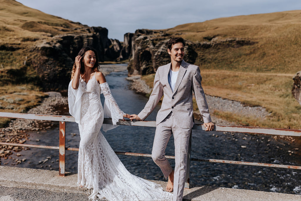 Destination Wedding Photographer captures bride and groom standing against railing together