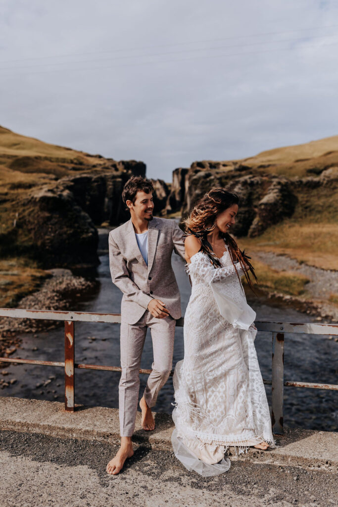 Destination wedding photographer captures bride and groom against railing during bridals after they elope in Iceland