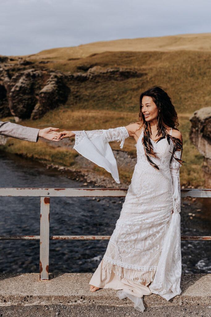 Destination wedding photographer captures bride holding groom's hand and looking at him